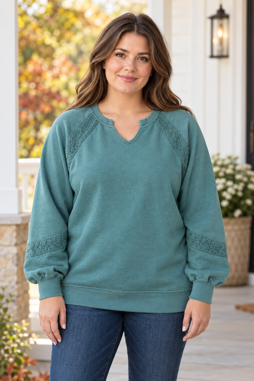 Model wearing a sage green Michelle Mae vintage-wash pullover with lace accent panels at the shoulders and sleeves and a notched neckline